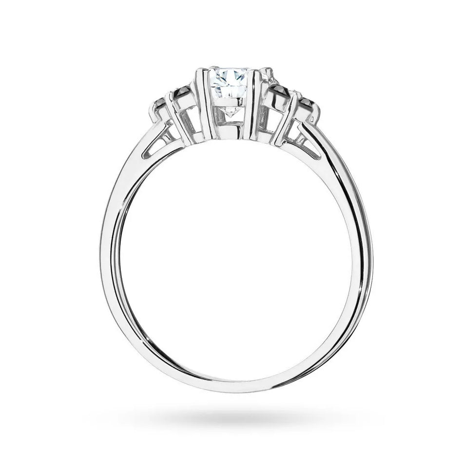 Prsteň z bieleho zlata 14k(585) so 0,60 ct bielym zafírom a 6 čiernymi diamantmi. Perfektný ako darček.