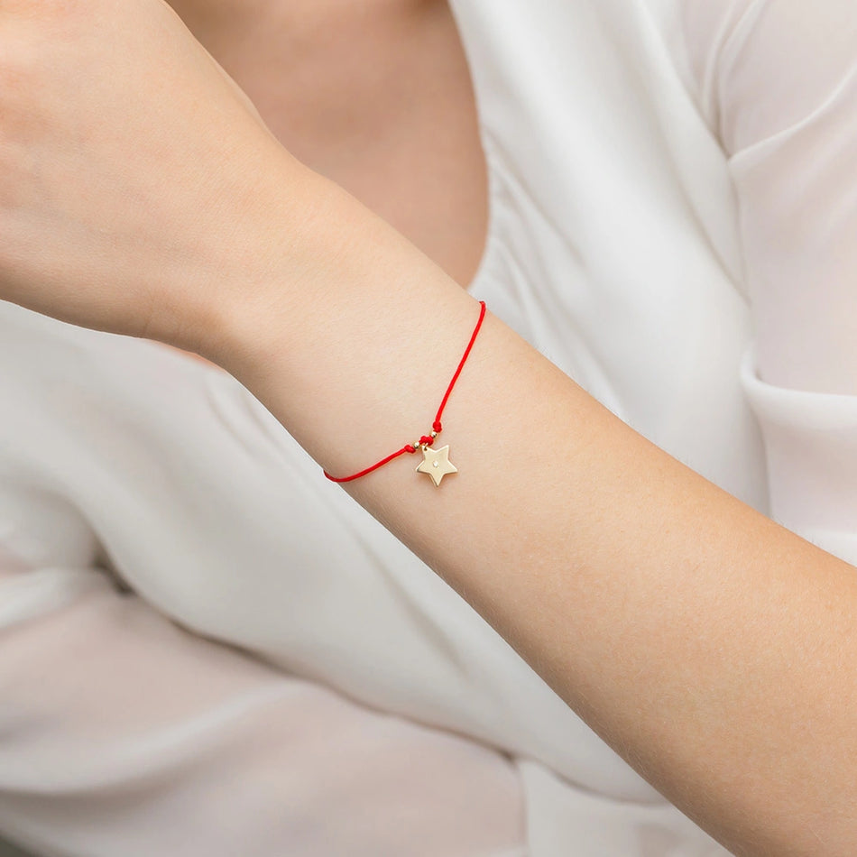 Zlatý náramok s diamantovou hviezdou na červenom šnúrke