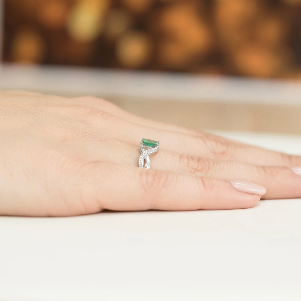 Prsteň nekonečna z bieleho 14k zlata s oválnym smaragdom 0,40 ct a diamantmi 0,05 ct