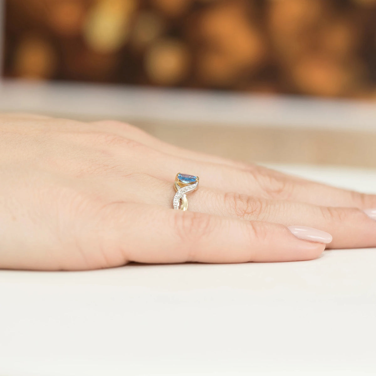 Prsteň nekonečna zo žltého 14k zlata s oválnym topásom Swiss Blue 0,50 ct a diamantmi 0,05 ct
