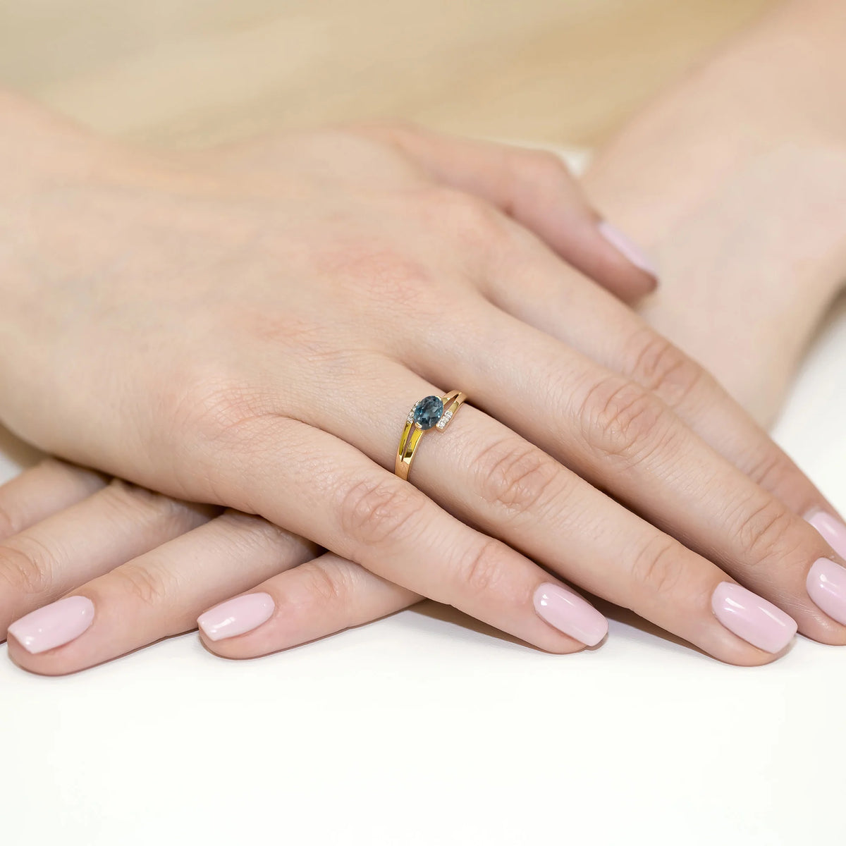 Prsteň s prekríženými ramenami zo žltého 14k zlata s oválnym topásom London Blue 0,50 ct a diamantmi 0,052 ct