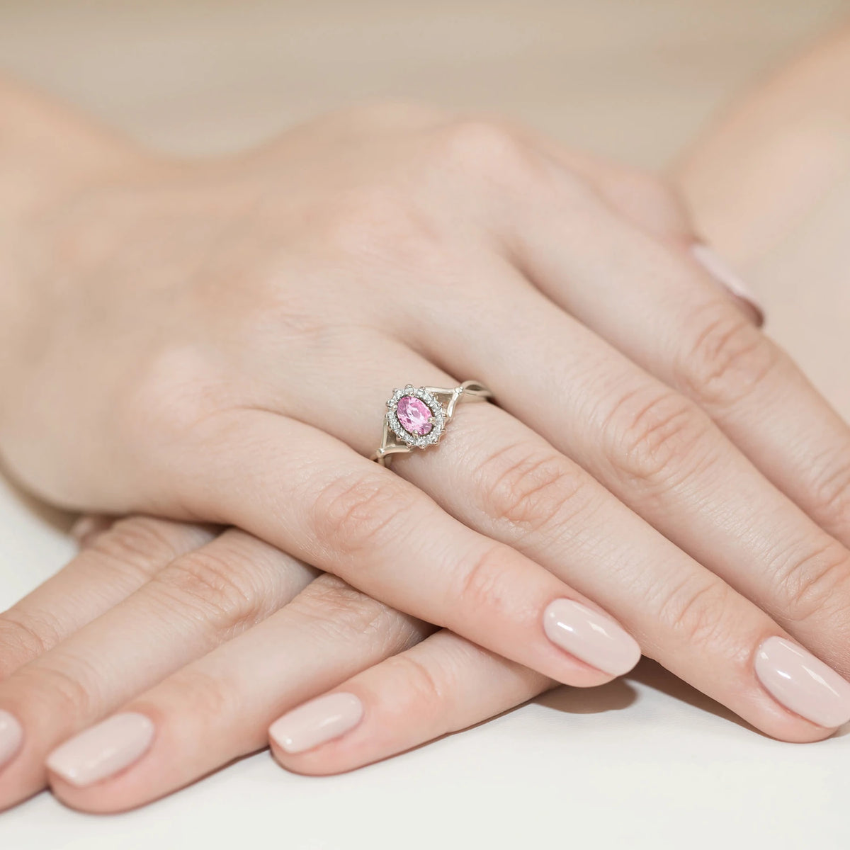 Halo prsteň z bieleho 14k zlata s delenými ramenami, oválnym ružovým zafírom 0,45 ct a diamantmi 0,12 ct