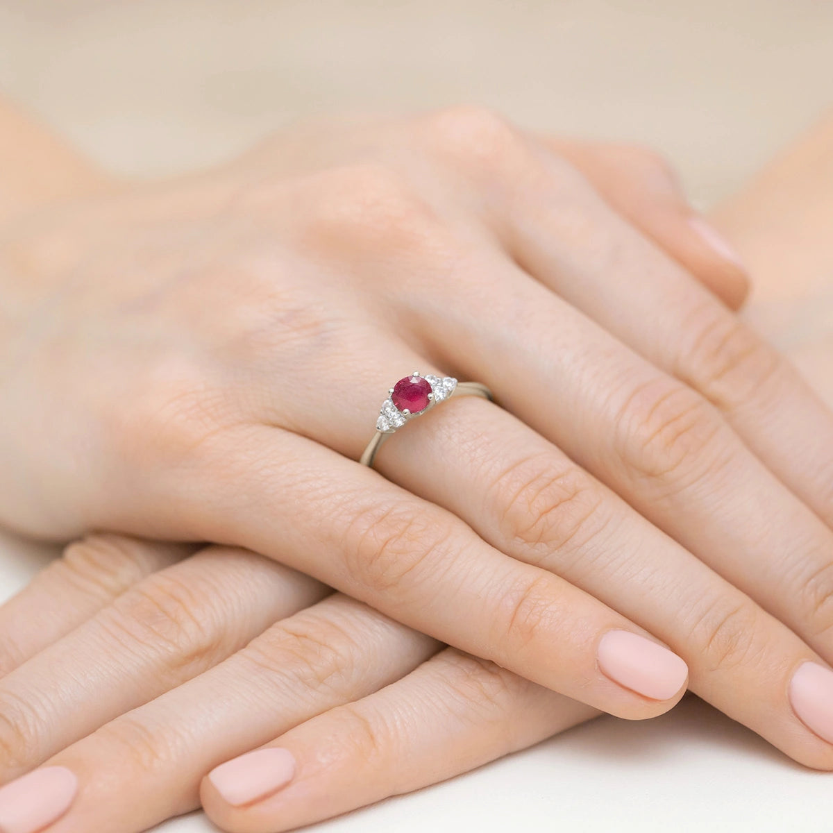 Prsteň z bieleho 14k zlata s okrúhlym rubínom 0,60 ct a postrannými zhluky diamantov 0,18 ct